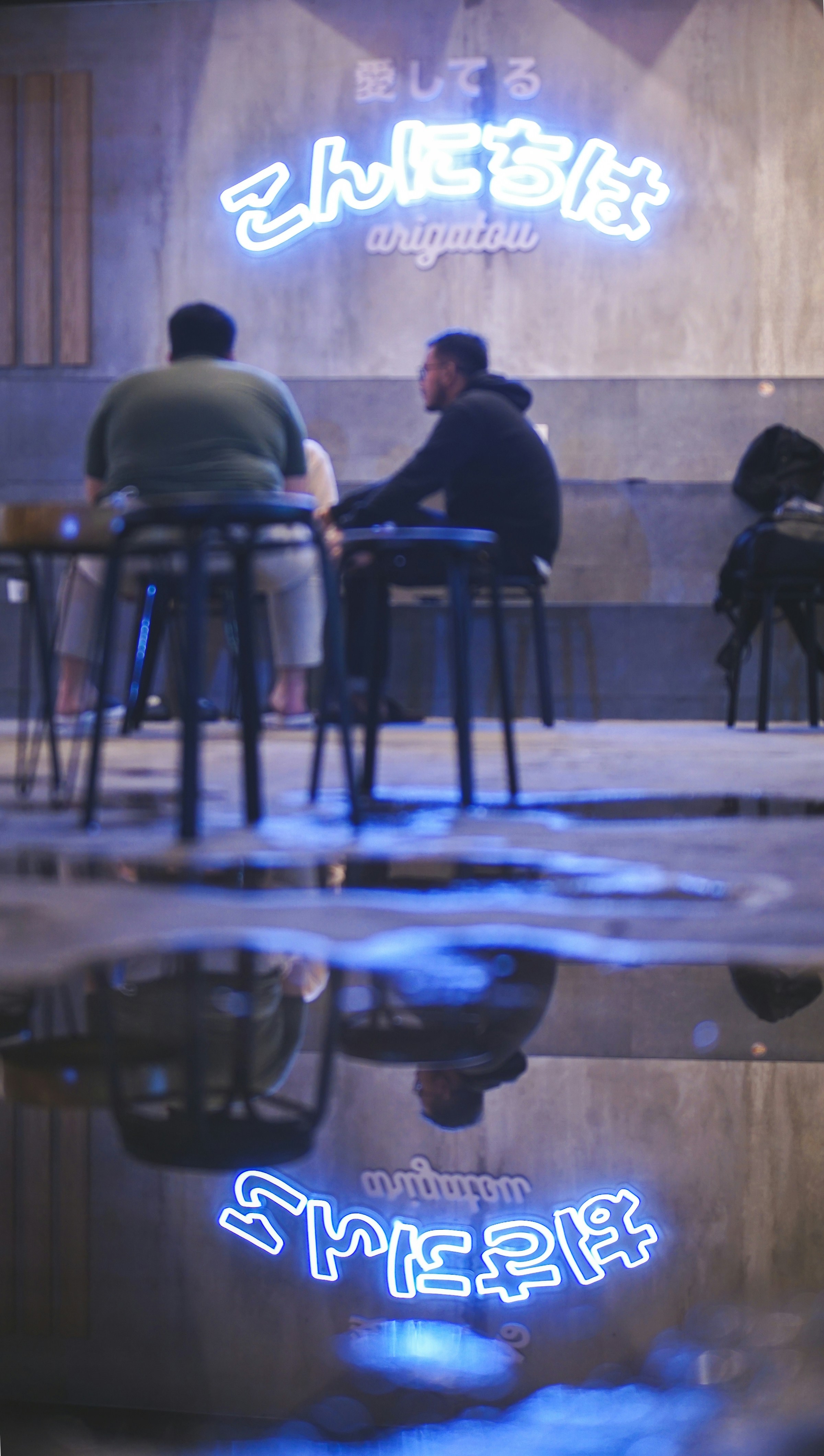 Ein paar Leute sitzen an einem Tisch vor einem Gebäude