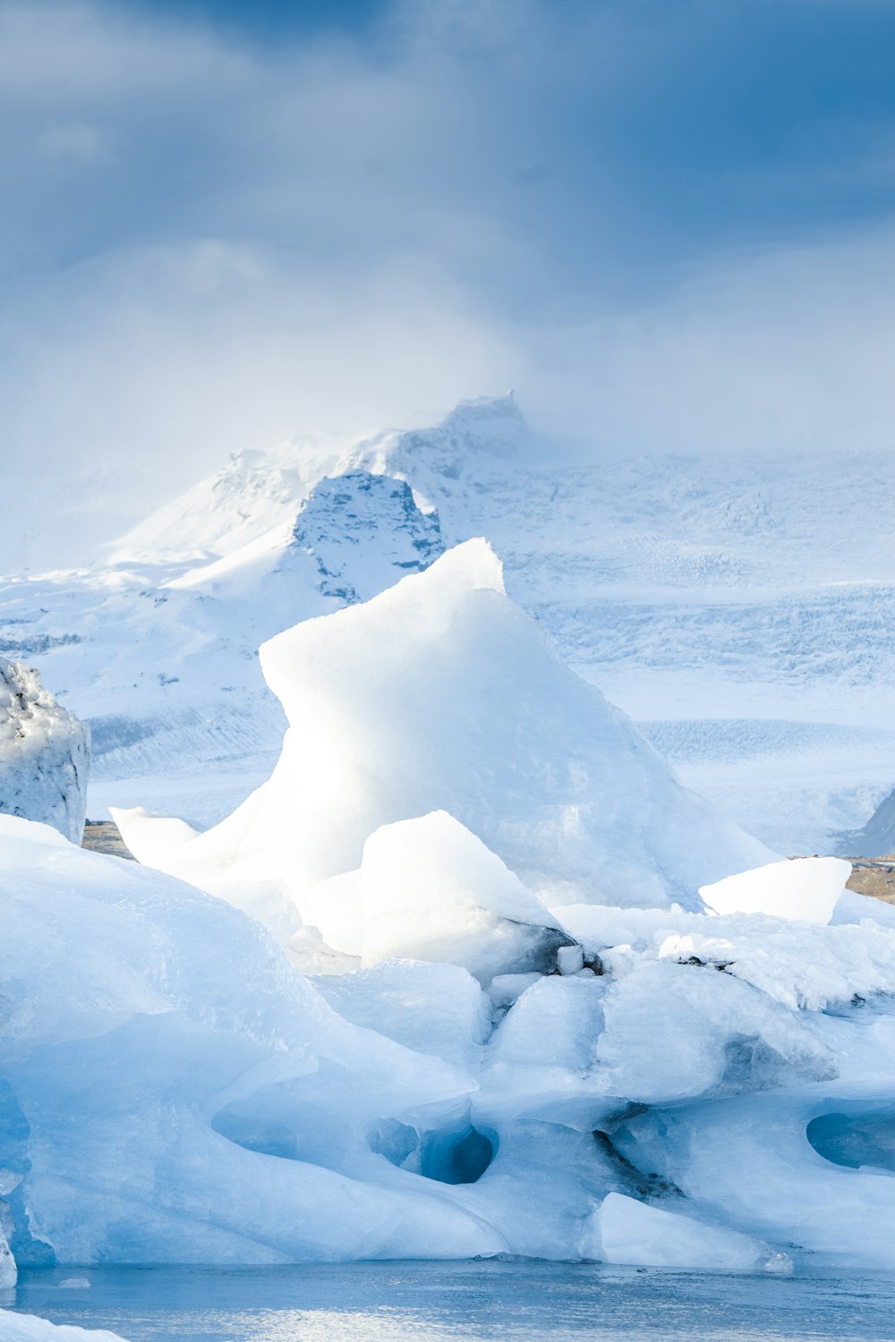 a group of snow covered mountains and a body of water