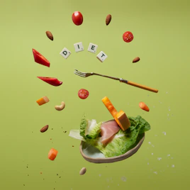 a piece of lettuce, carrots, tomatoes, and a fork are