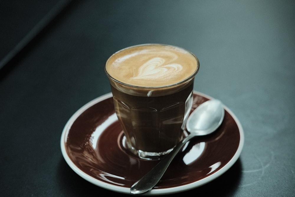 a cup of coffee on a saucer with a spoon