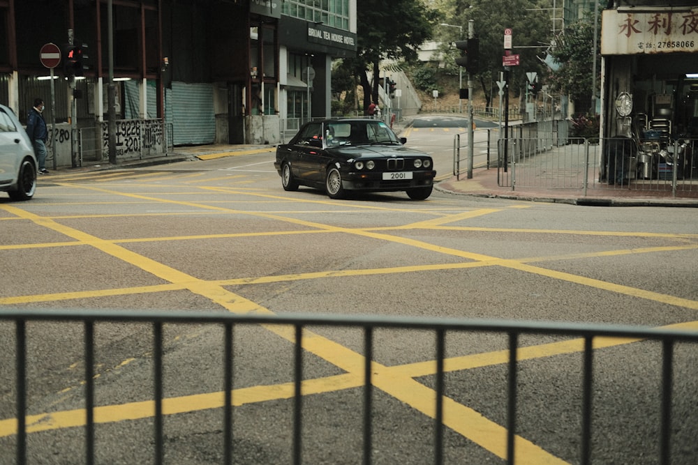 a car driving down a street next to a tall building