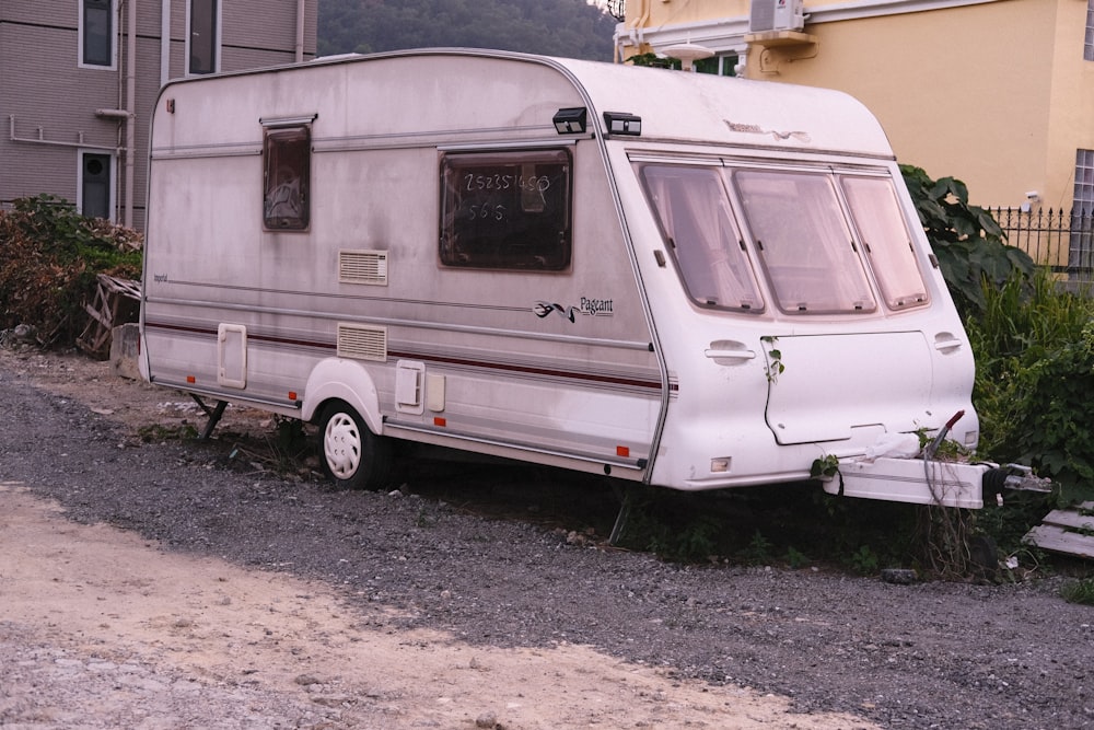an old camper parked in front of a house