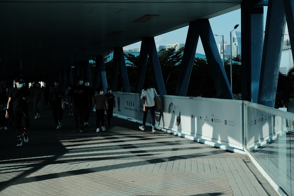 a group of people walking across a bridge