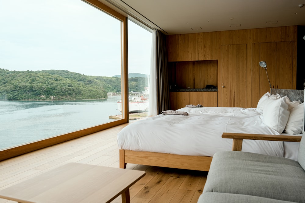 a bedroom with a large window overlooking a body of water