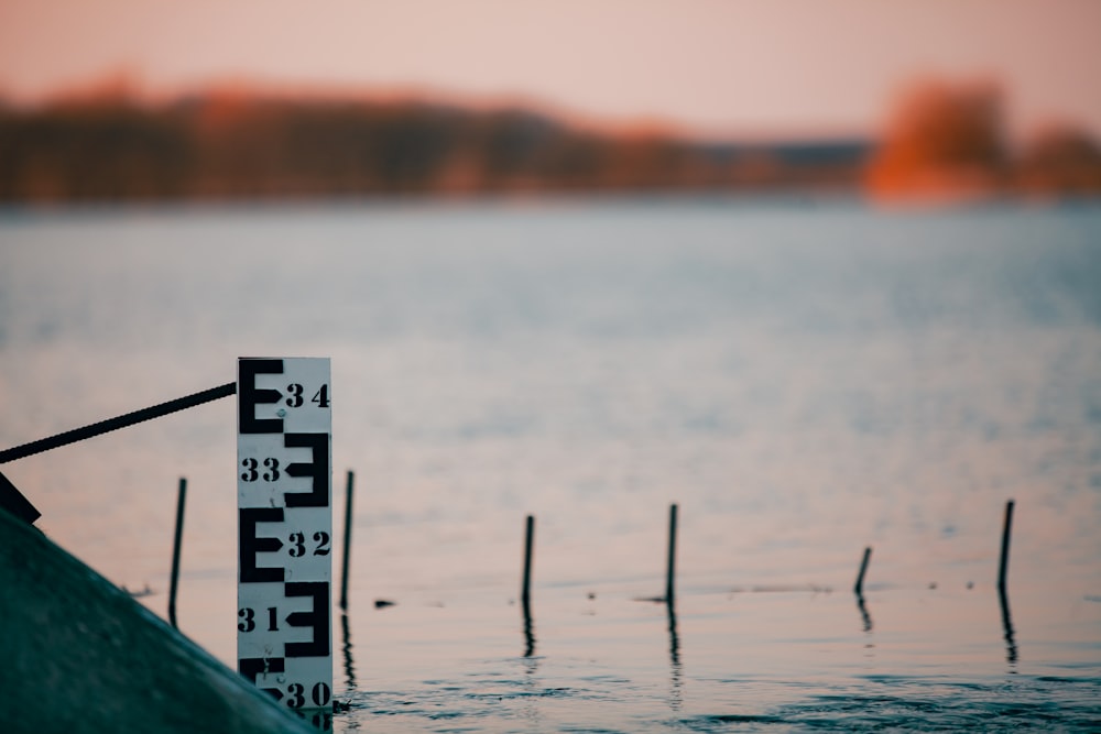 a thermometer sitting on a pole in the water