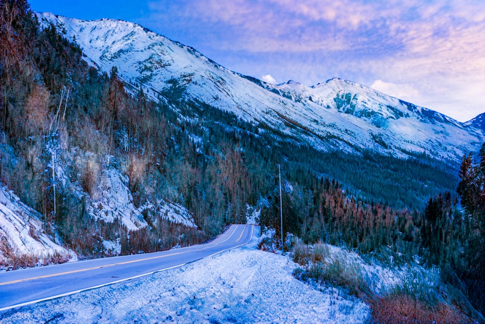 a snowy mountain with a road in the foreground
