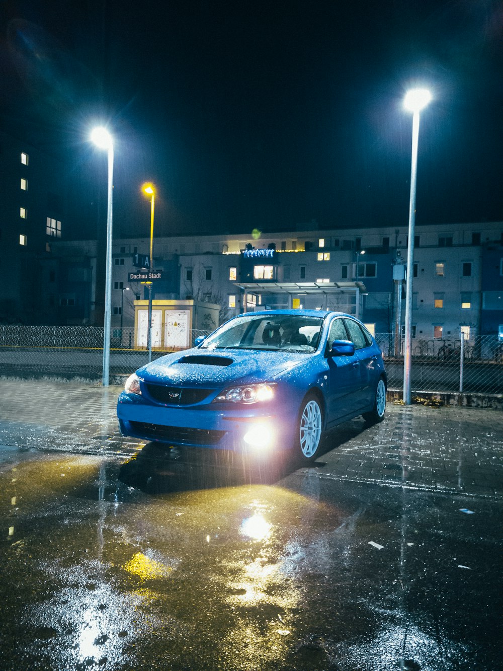 un'auto blu parcheggiata in un parcheggio di notte