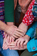 a group of people stacking their hands together