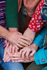 a group of people stacking their hands together