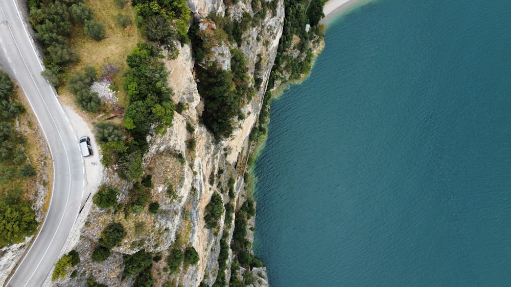 an aerial view of a road and a body of water