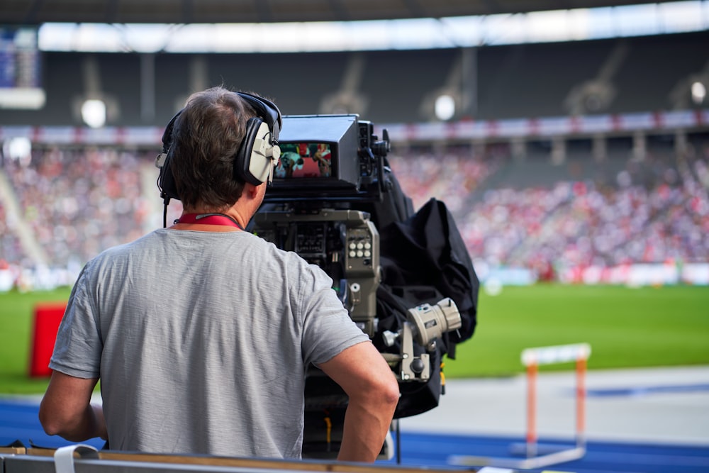 a man with headphones on sitting in front of a camera