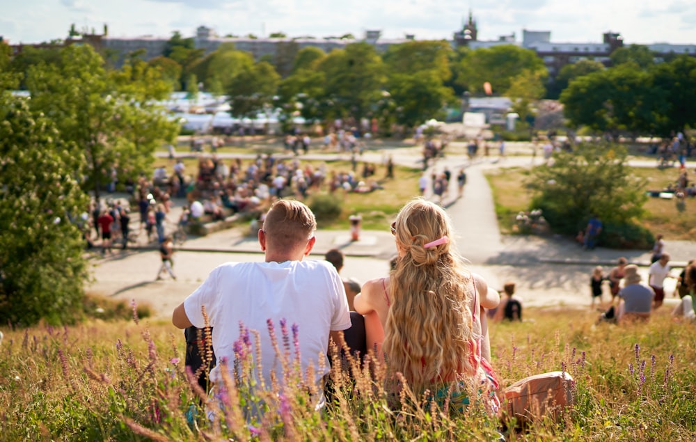 a couple of people that are sitting in the grass