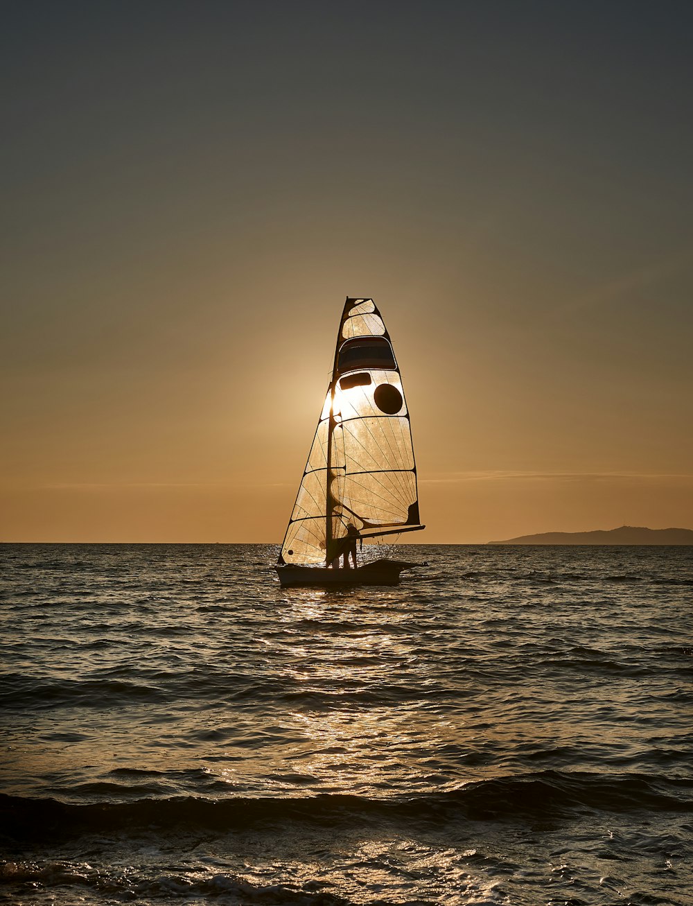 Ein Segelboot, das bei Sonnenuntergang auf dem Ozean segelt