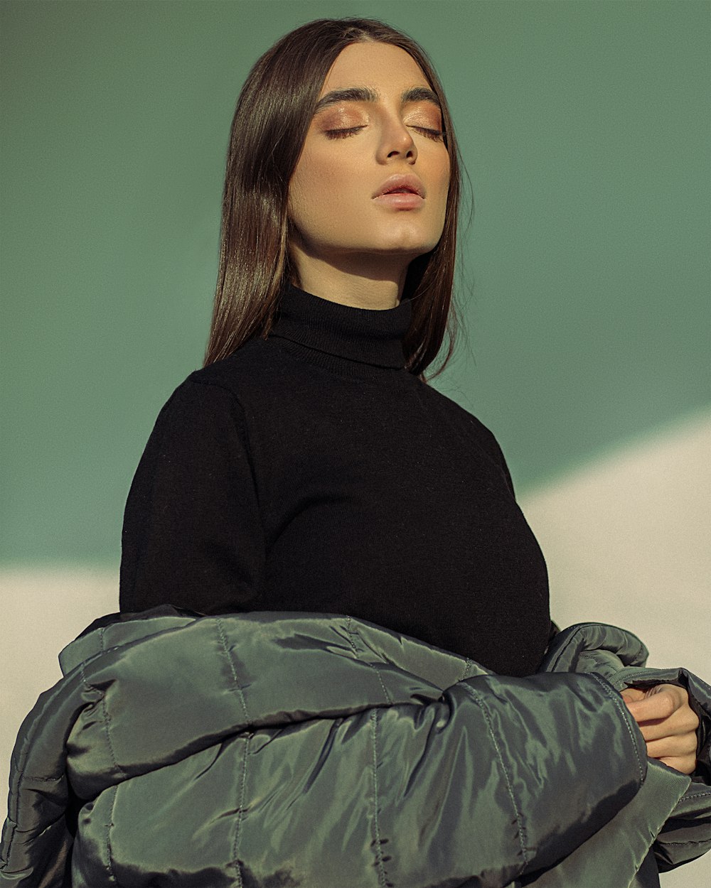 a woman in a black top and a silver jacket