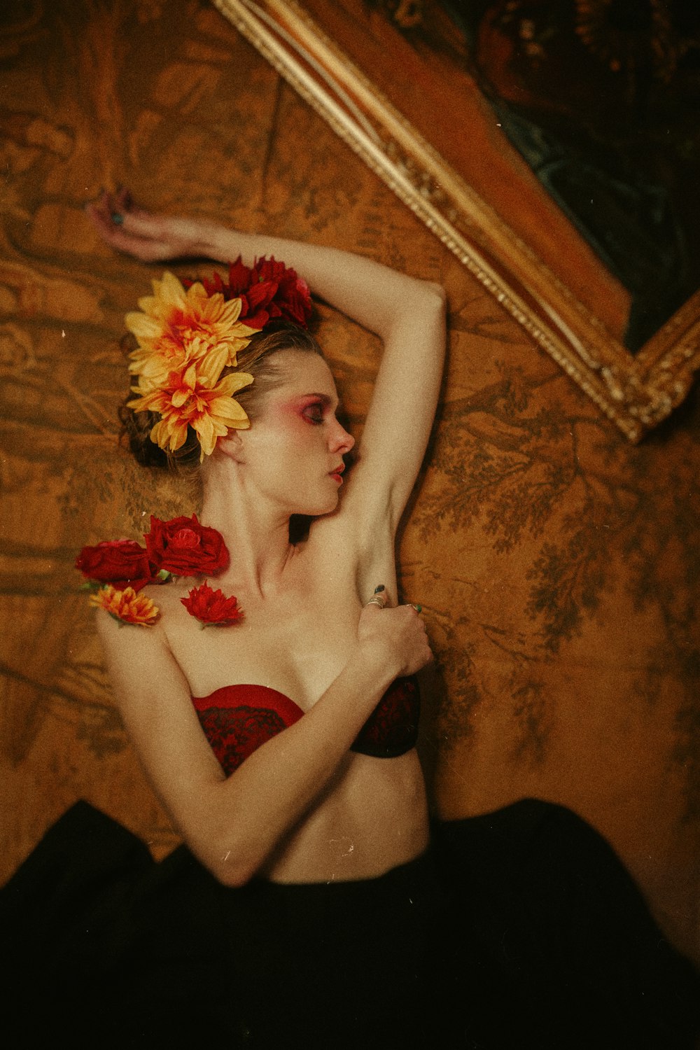 a woman with flowers in her hair laying on a bed
