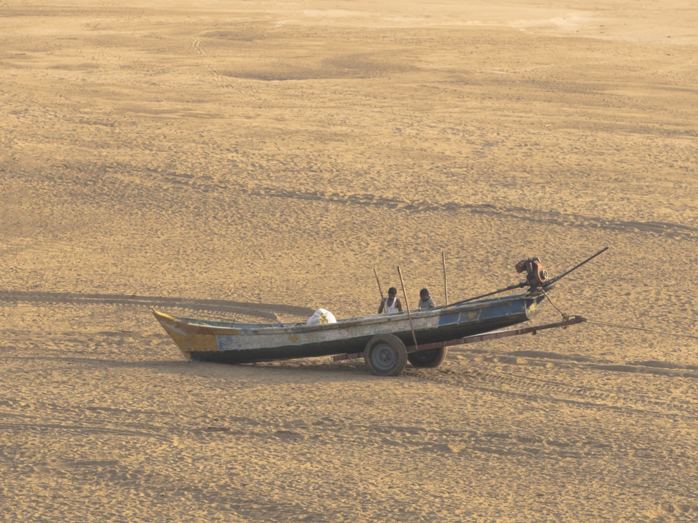 a boat sitting on top of a sandy beach