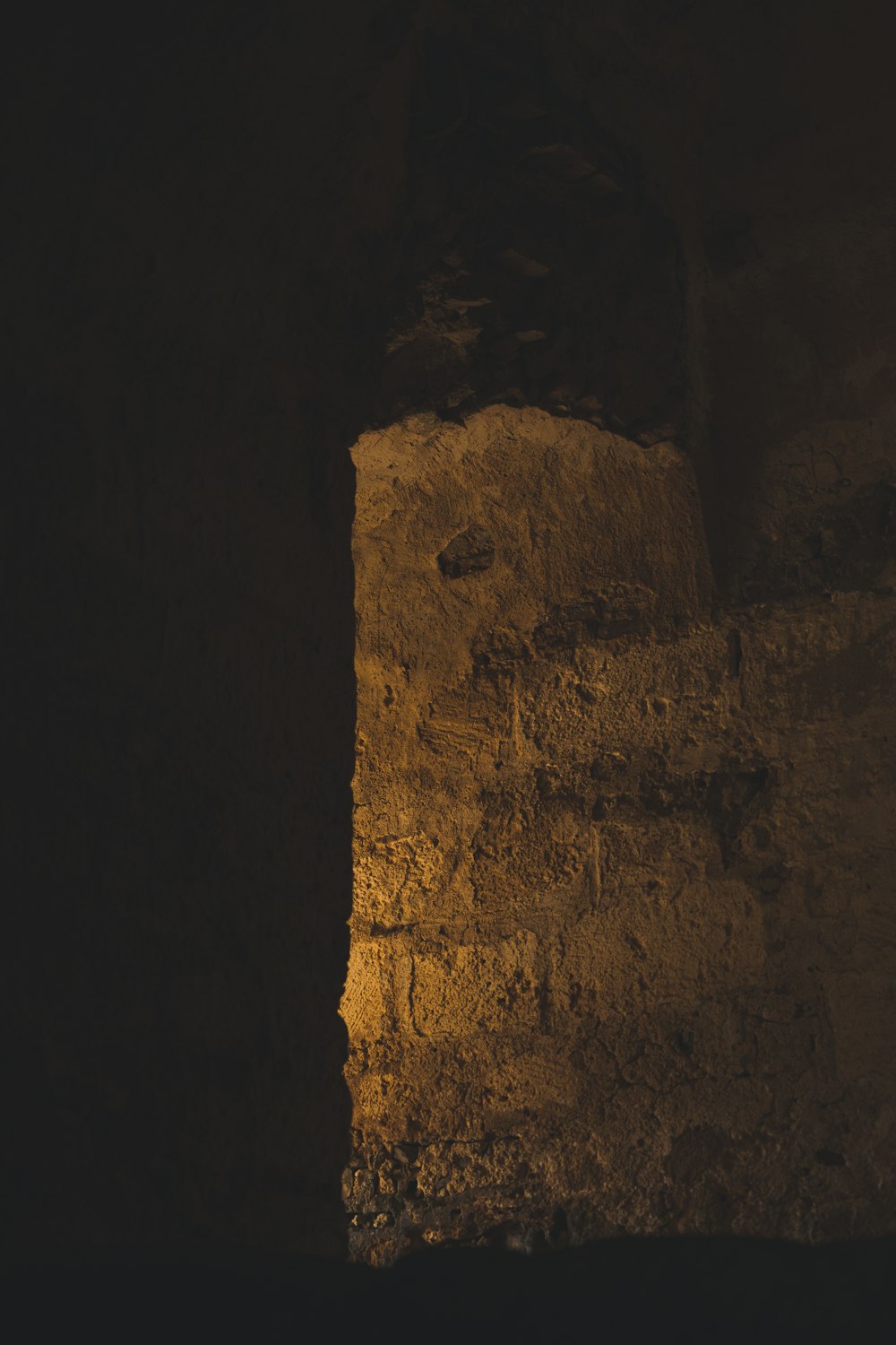 a stone wall with a light shining through it