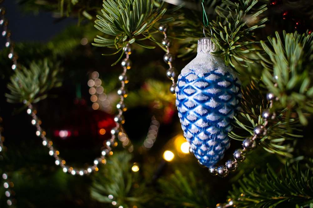 a blue and white ornament hanging from a christmas tree