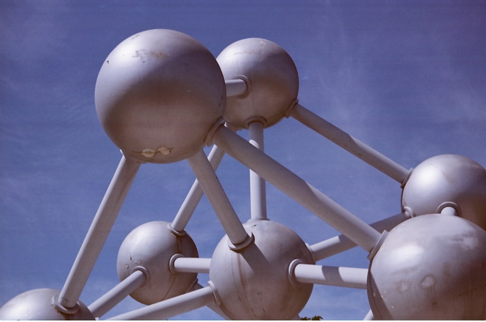 a group of metal balls and poles against a blue sky
