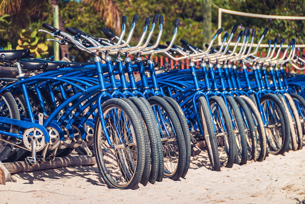 a row of blue bicycles parked next to each other