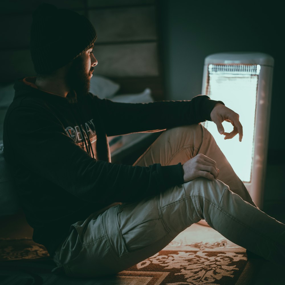 a man sitting on a bed in a dark room