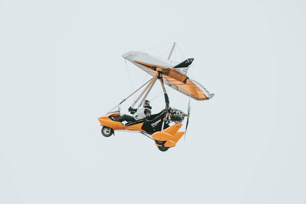 a man riding on the back of an orange motorcycle in the air