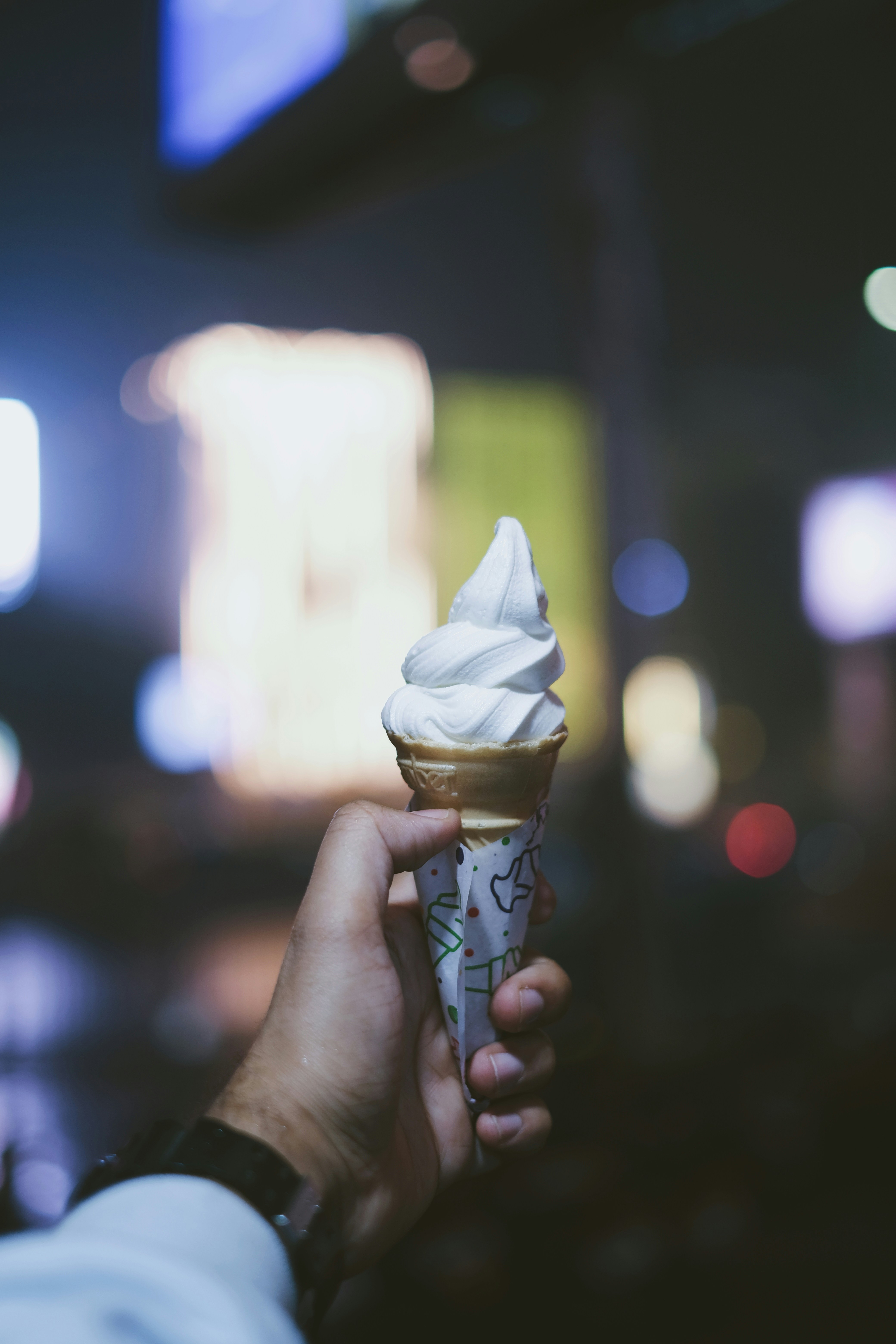 A person holding an ice cream cone in their hand photo Free India