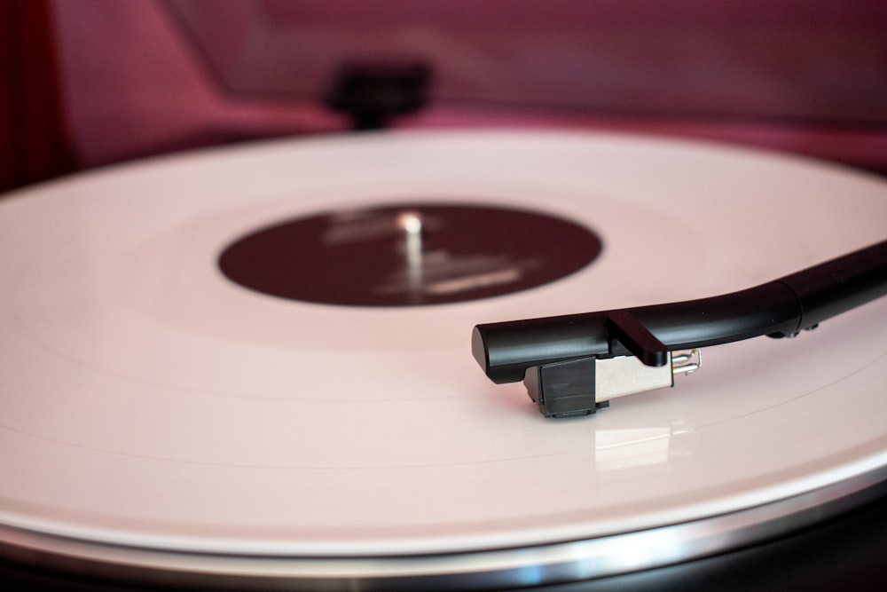 a white record player with a black handle