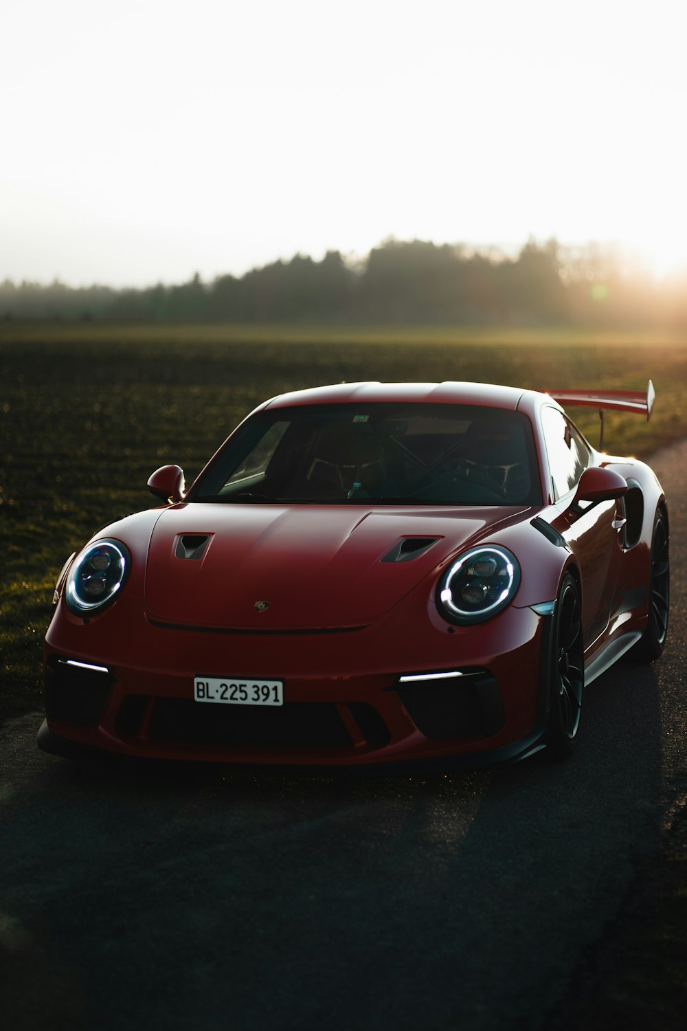 a red sports car driving down a road