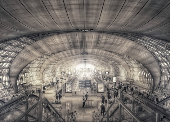 A sleek, futuristic airport terminal bathed in soft royal blue and gold lighting, embodying luxury and calm.