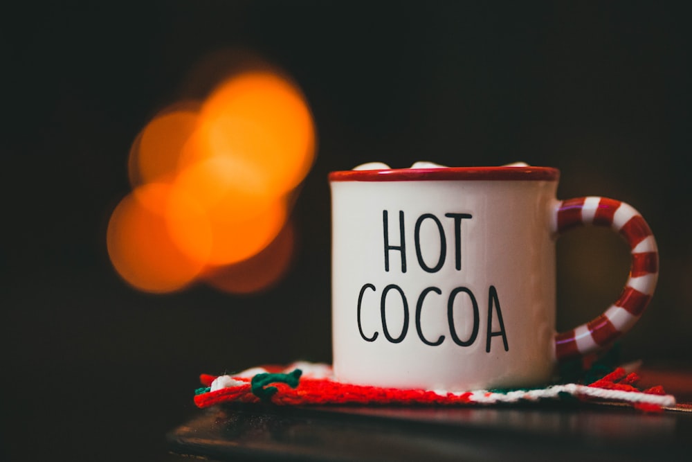 a red and white coffee mug sitting on top of a table