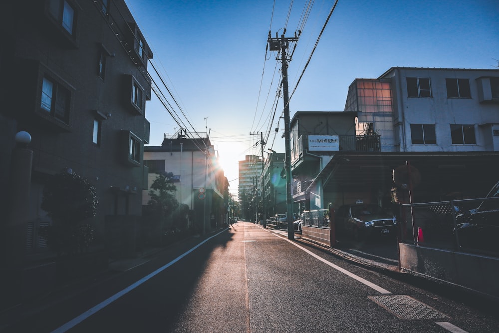 the sun is setting on a city street