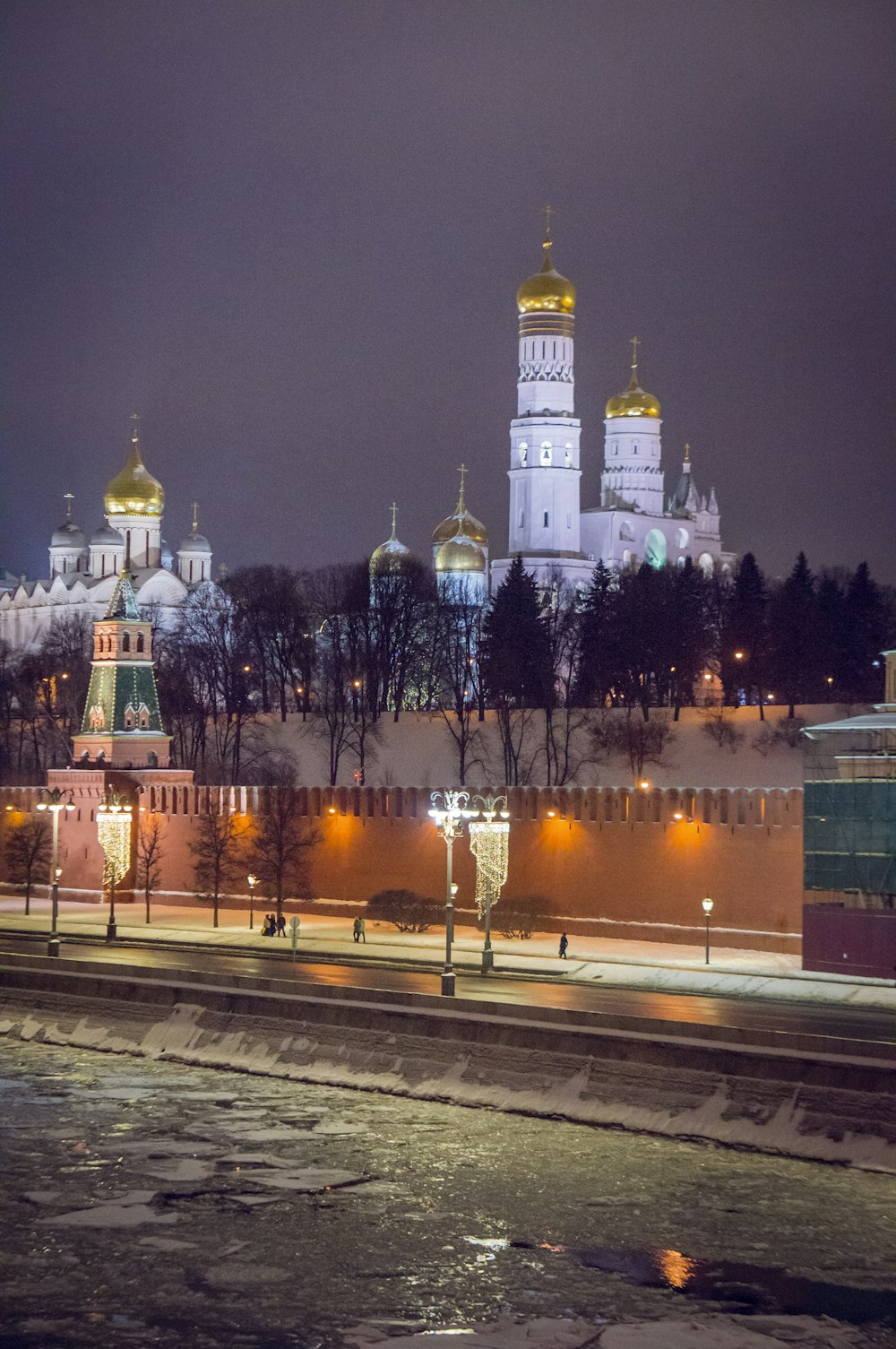 a night view of a city with a castle in the background