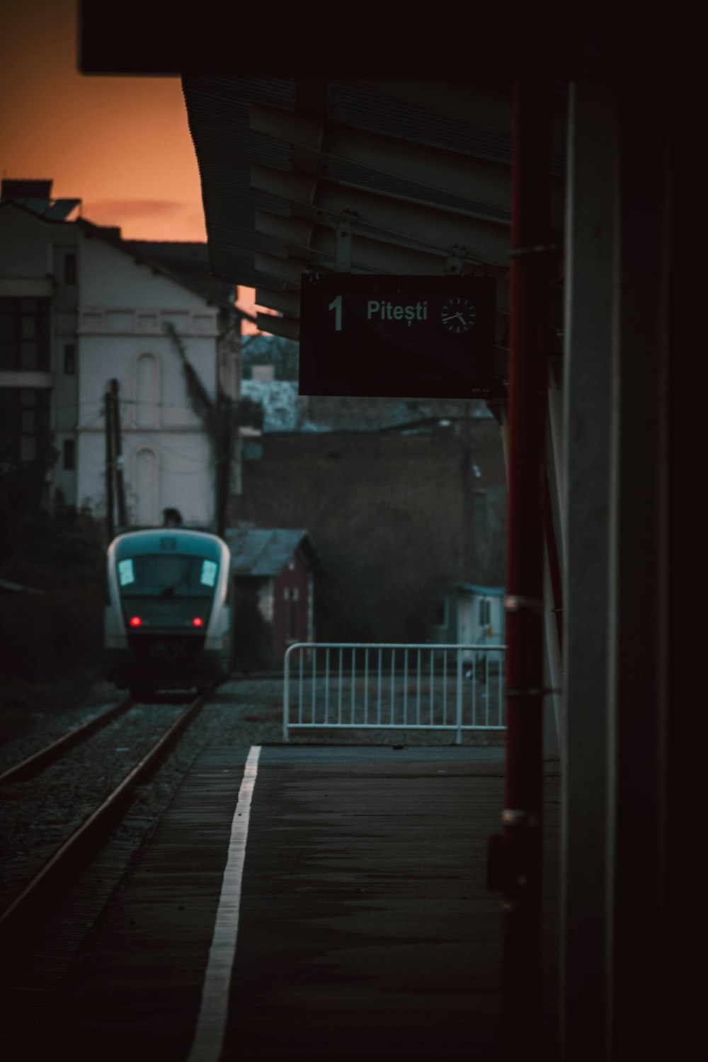 a train traveling down train tracks next to a train station