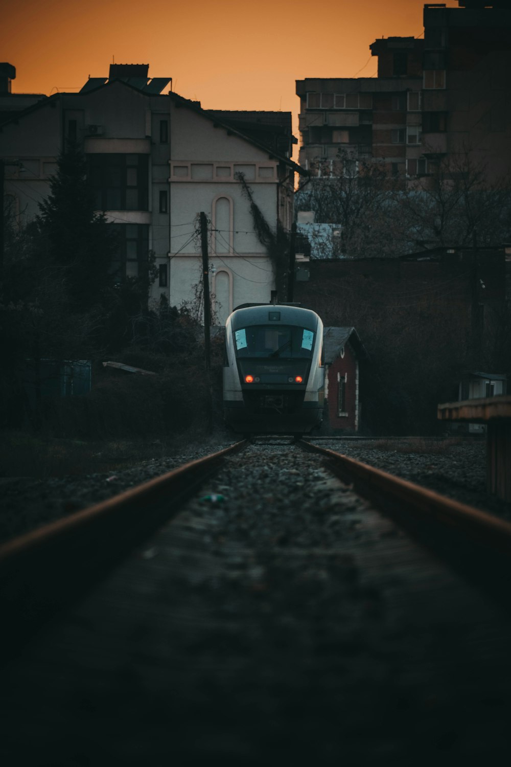 a train traveling down train tracks next to tall buildings