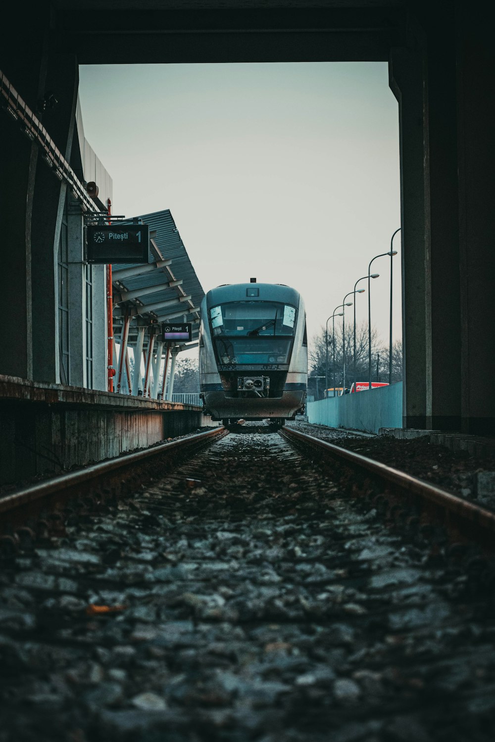 a train traveling down train tracks under a bridge