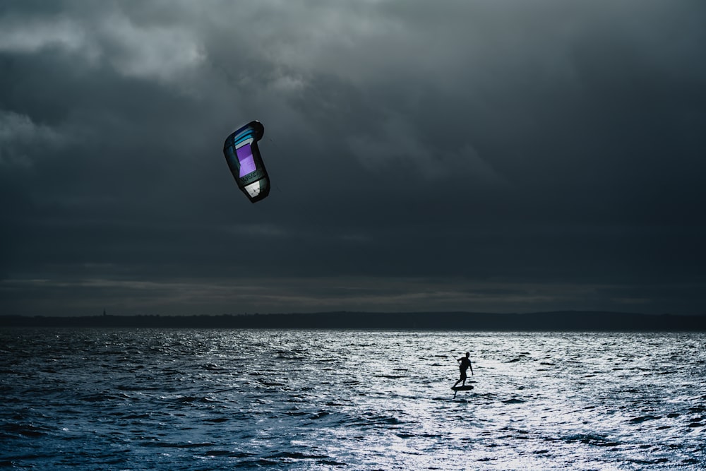 a person on a surfboard with a kite in the air