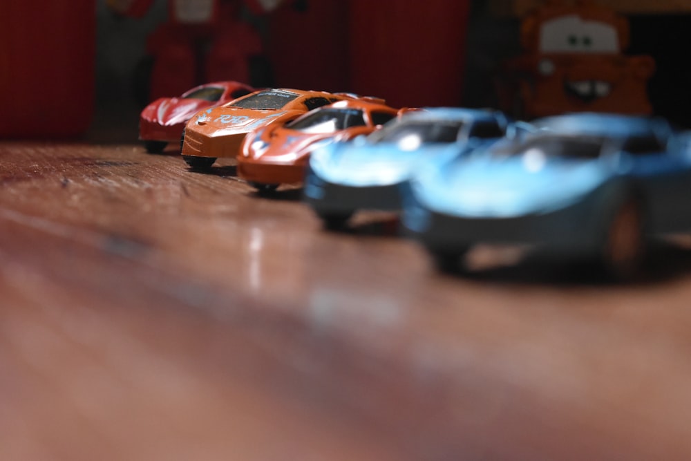 a row of toy cars sitting on top of a wooden floor