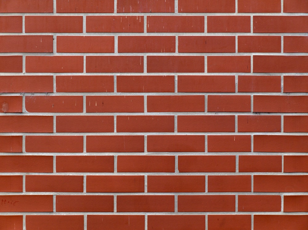 a red brick wall with a clock on it