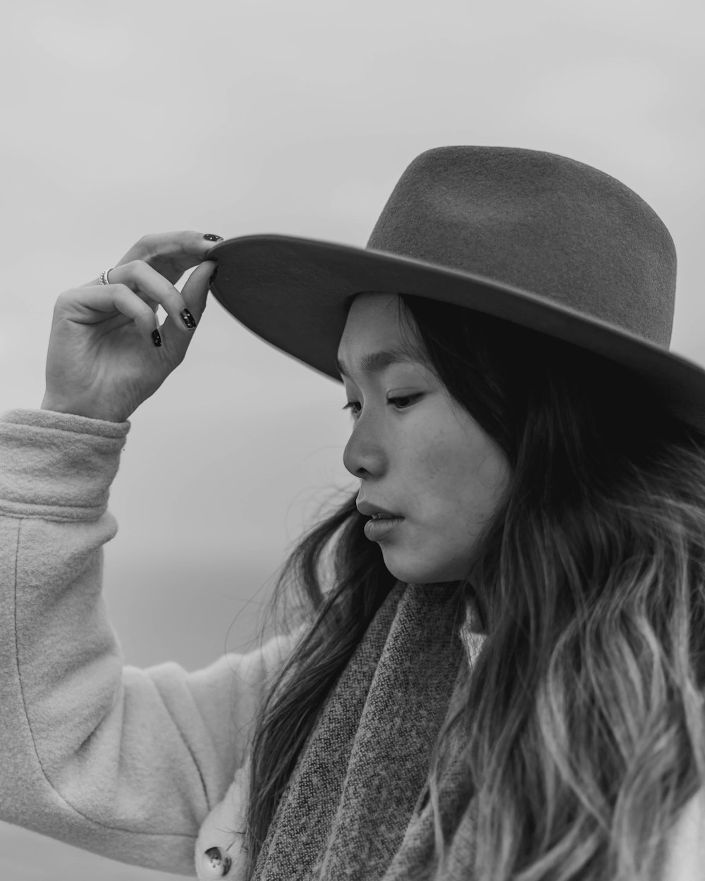 a woman with long hair wearing a hat and scarf