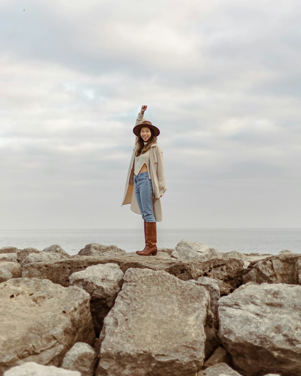 a woman standing on top of a pile of rocks