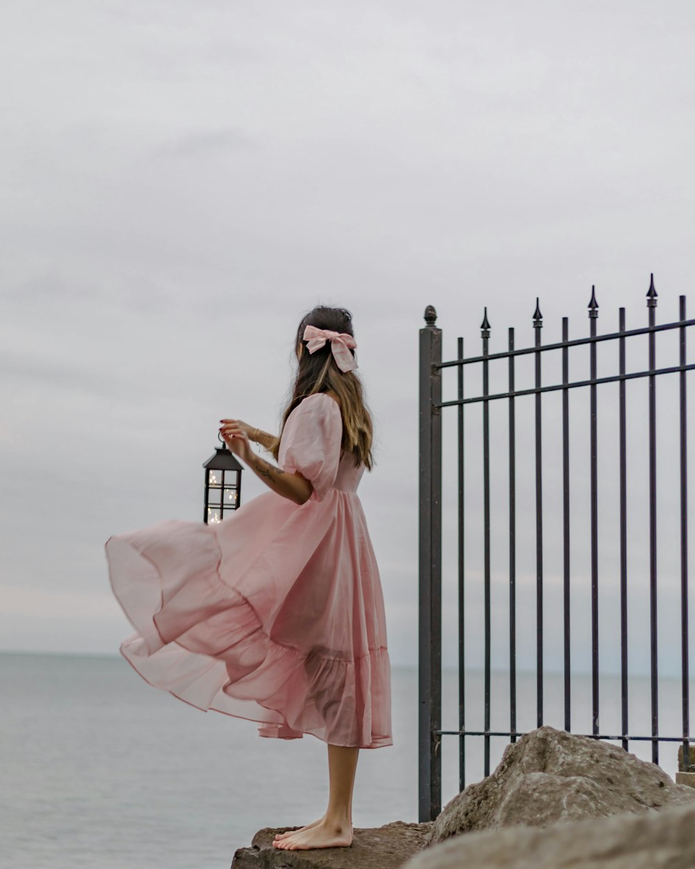 Eine Frau in einem rosa Kleid, die eine Laterne hält