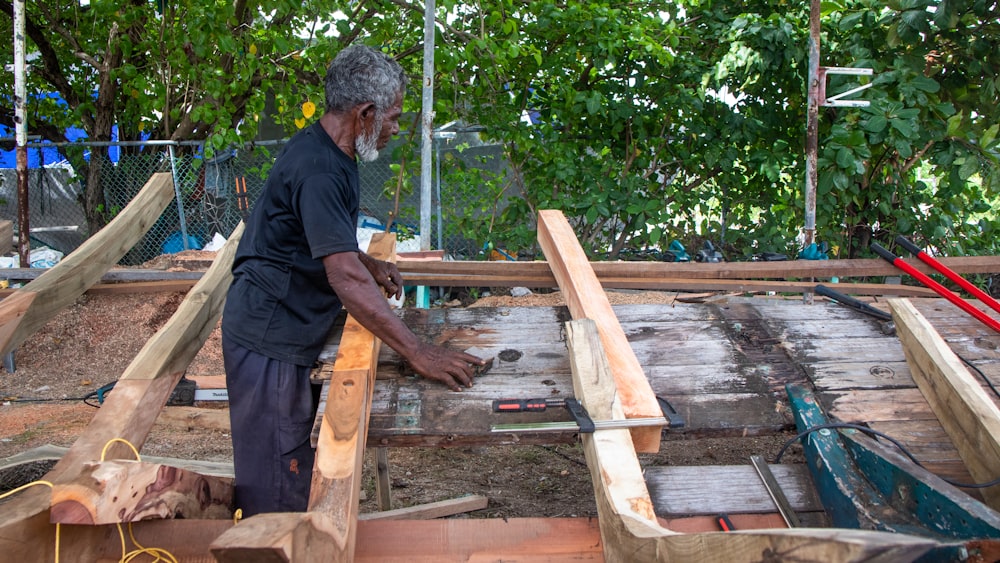 a man is working on a wooden structure