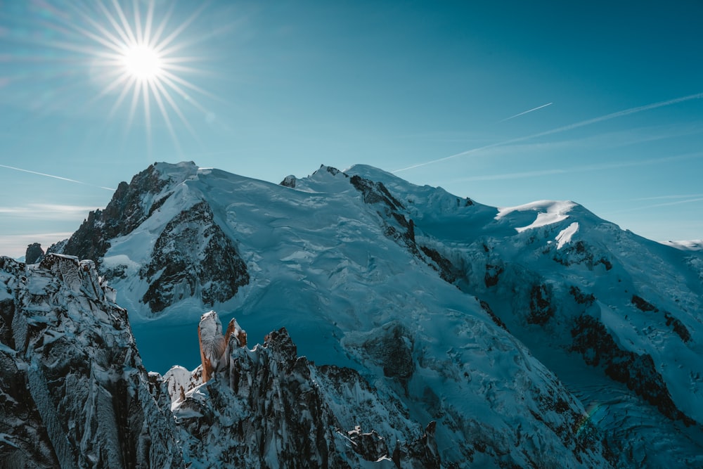 the sun shines brightly over a snowy mountain