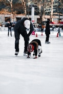 Coach encouraging a young skater during a lesson inside an ice rink