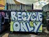 a dumpster covered in graffiti next to a building
