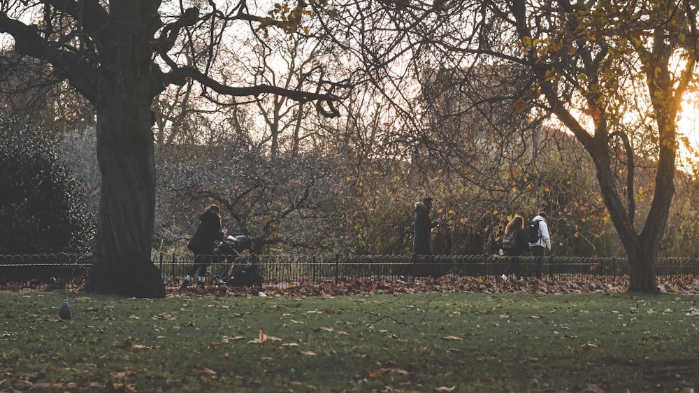 a group of people riding horses through a park