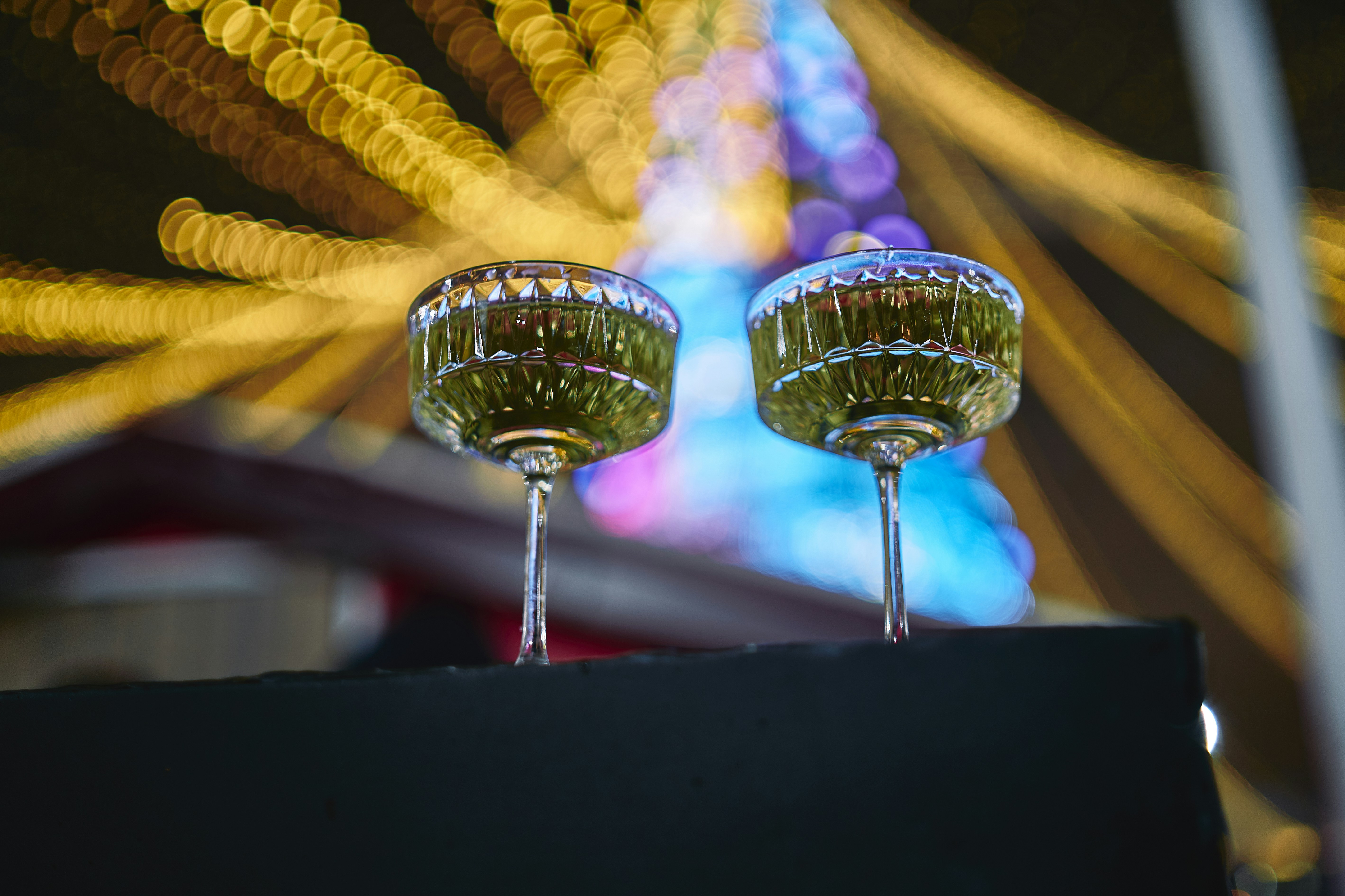 two wine glasses sitting on top of a black box