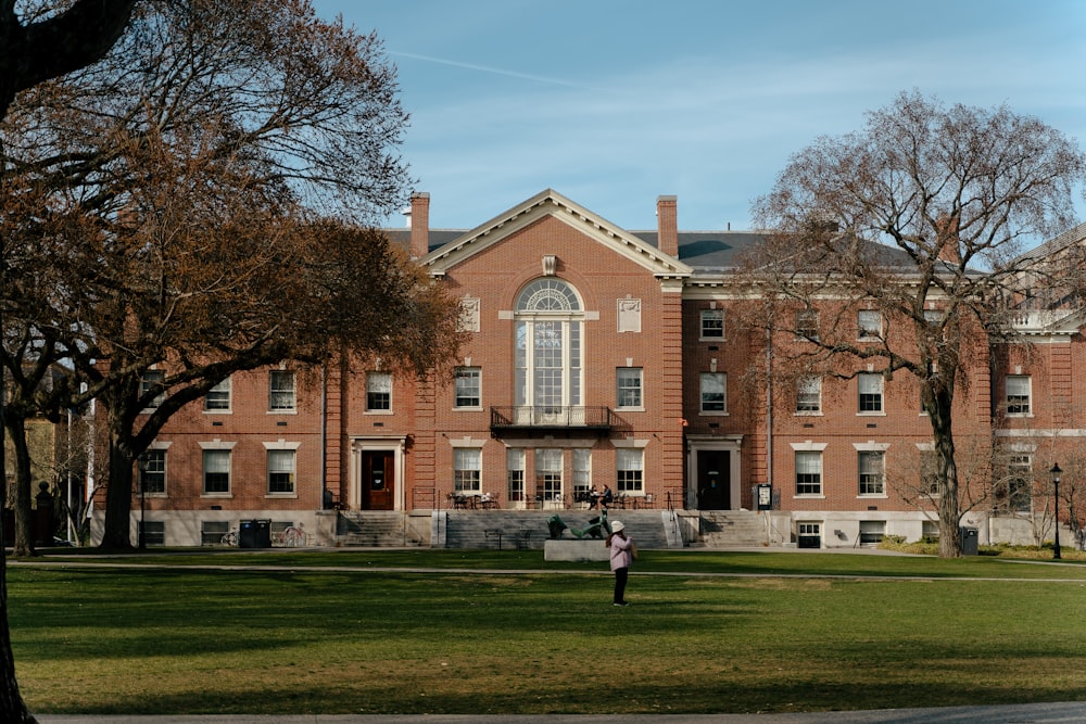 a person standing in front of a large brick building