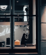 A dimly lit Tokyo bar with a mysterious woman sitting alone at the counter.